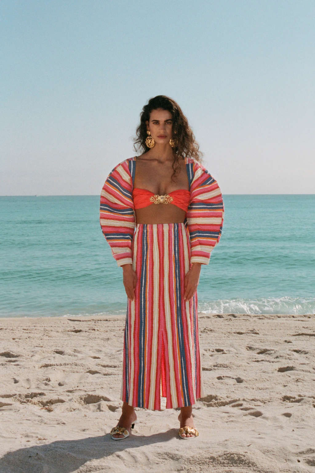 Chica en la playa con vestido de colores de mangas anchas abullonada