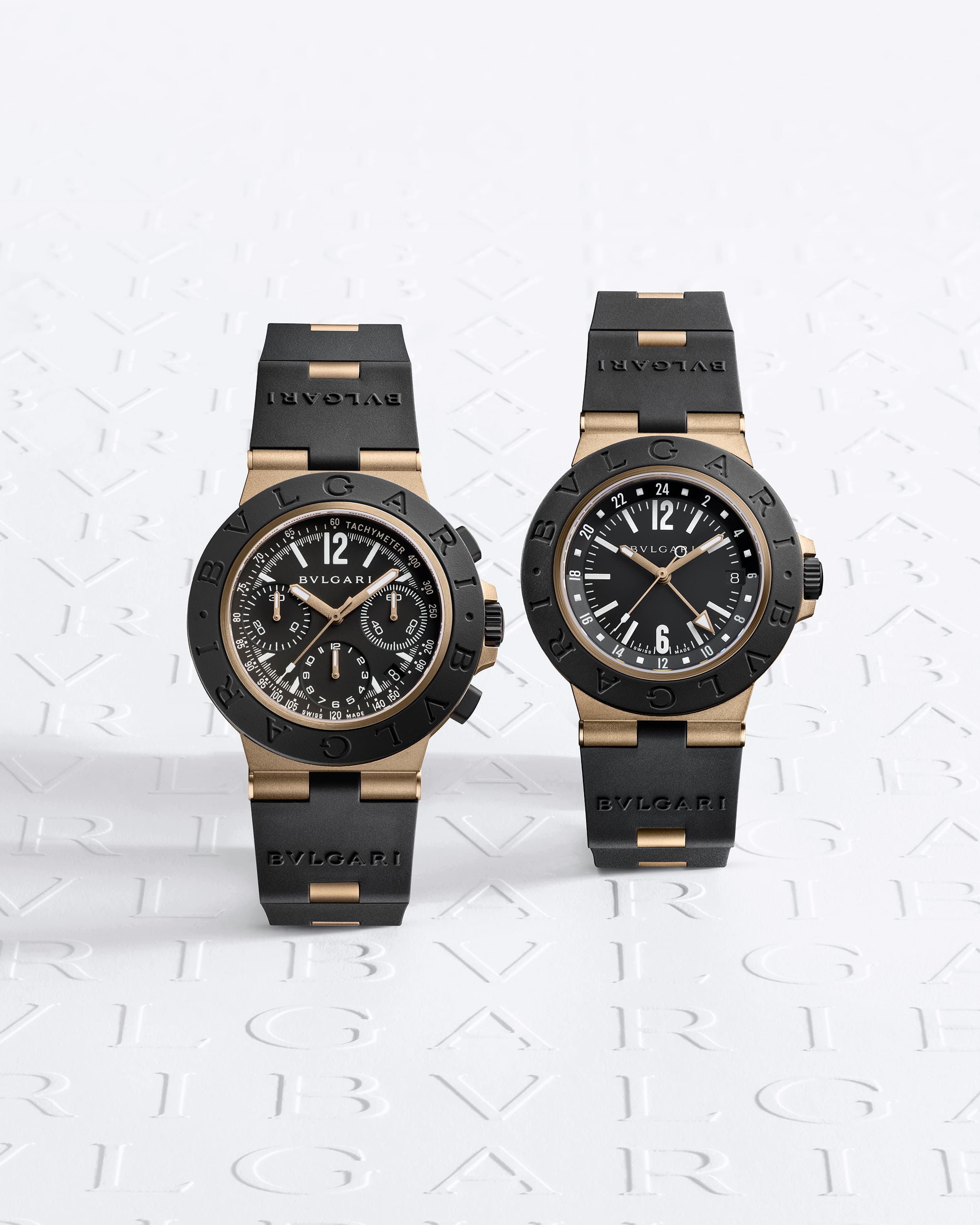 Dos relojes deportivos de caucho y bronce sobre fondo blanco papel Bvlgari. Bvlgari Bronzo GMT y Bronzo Cronógrafo