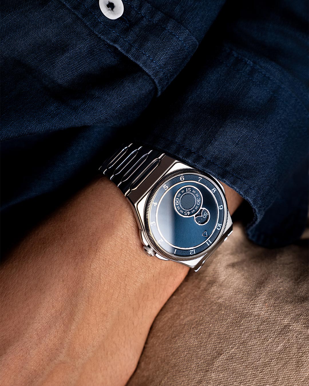 Colección nueva Trilobe Trente-Deux. Reloj acero en muñeca con camisa vaquera y fondo tela texturizada