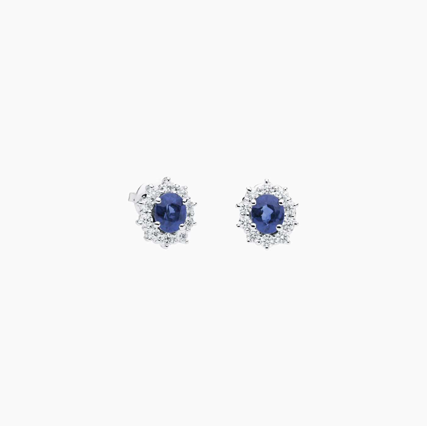 Pendientes de oro blanco con zafiro azul central talla oval y orla de diamantes
