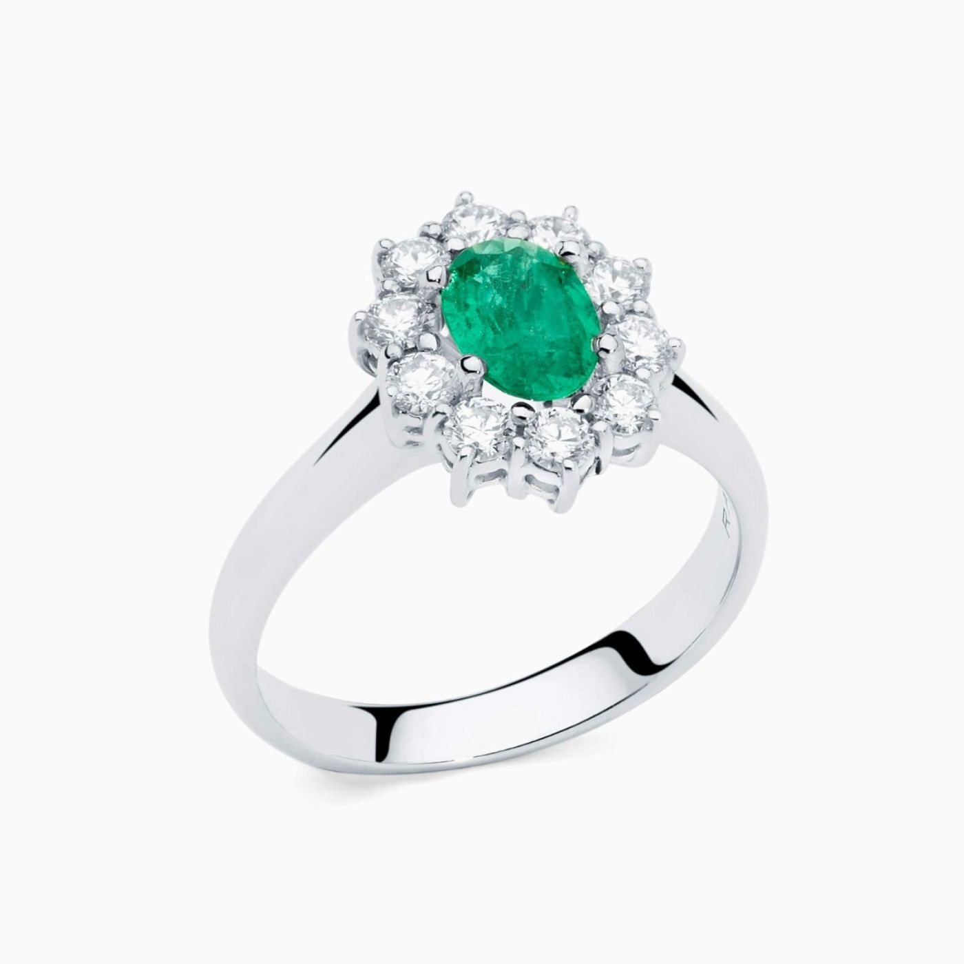 Anillo solitario de oro blanco con esmeralda central talla oval y orla de diamantes