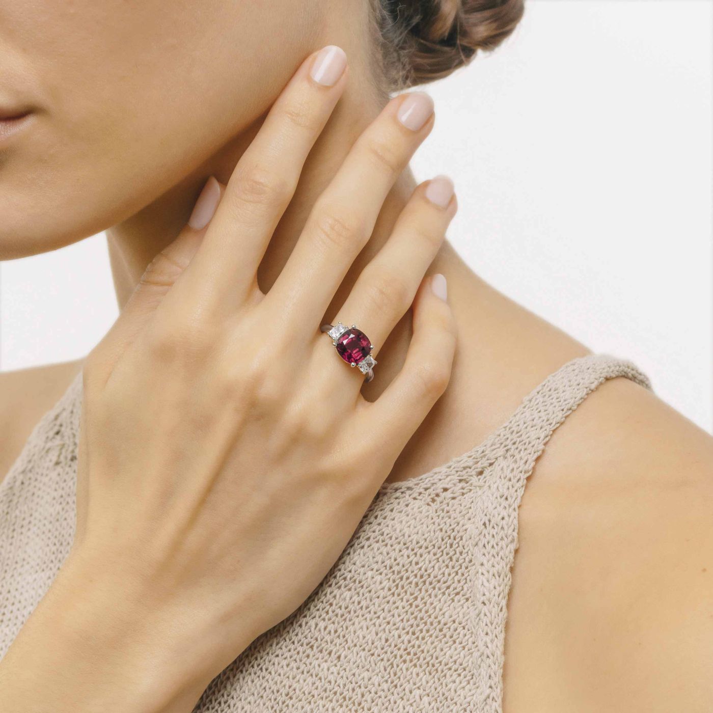 White gold with a ruby in the center and diamonds in the side solitaire ring