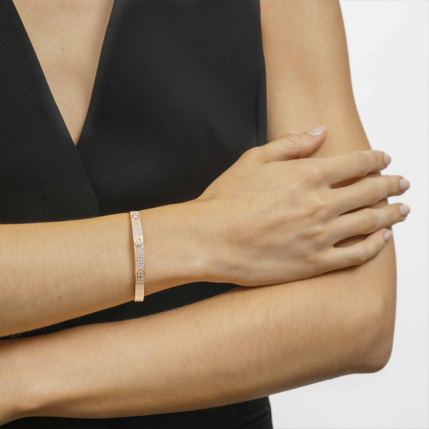 Pulsera rígida de oro rosa con tres diamantes centrales y pavé de diamantes