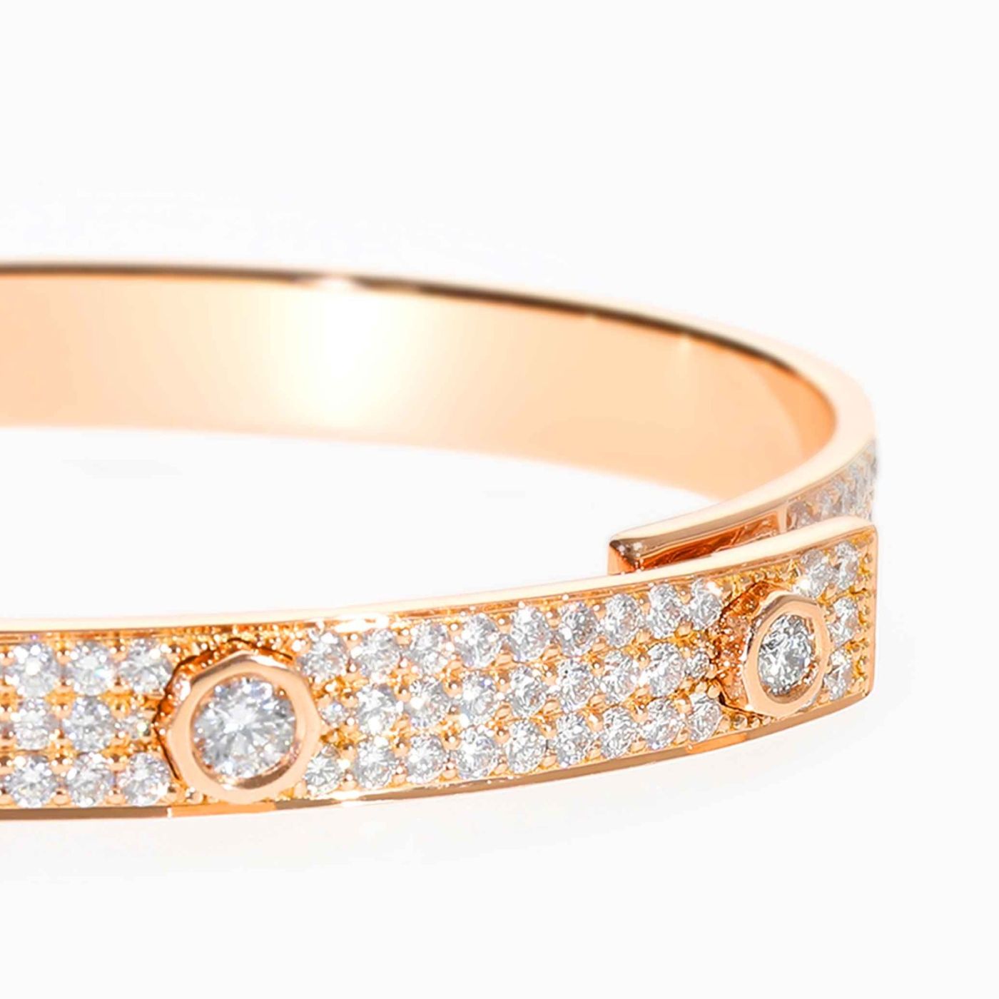 Pulsera rígida de oro rosa con tres diamantes centrales y pavé de diamantes