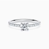 White gold solitaire engagement ring with a central diamond and diamond band
