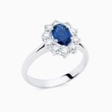 Anillo solitario de oro blanco con zafiro azul central talla oval y orla de diamantes