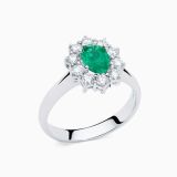 Anillo solitario de oro blanco con esmeralda central talla oval y orla de diamantes