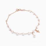 Pulsera infantil de oro rosa con perlas y una cruz de diamantes