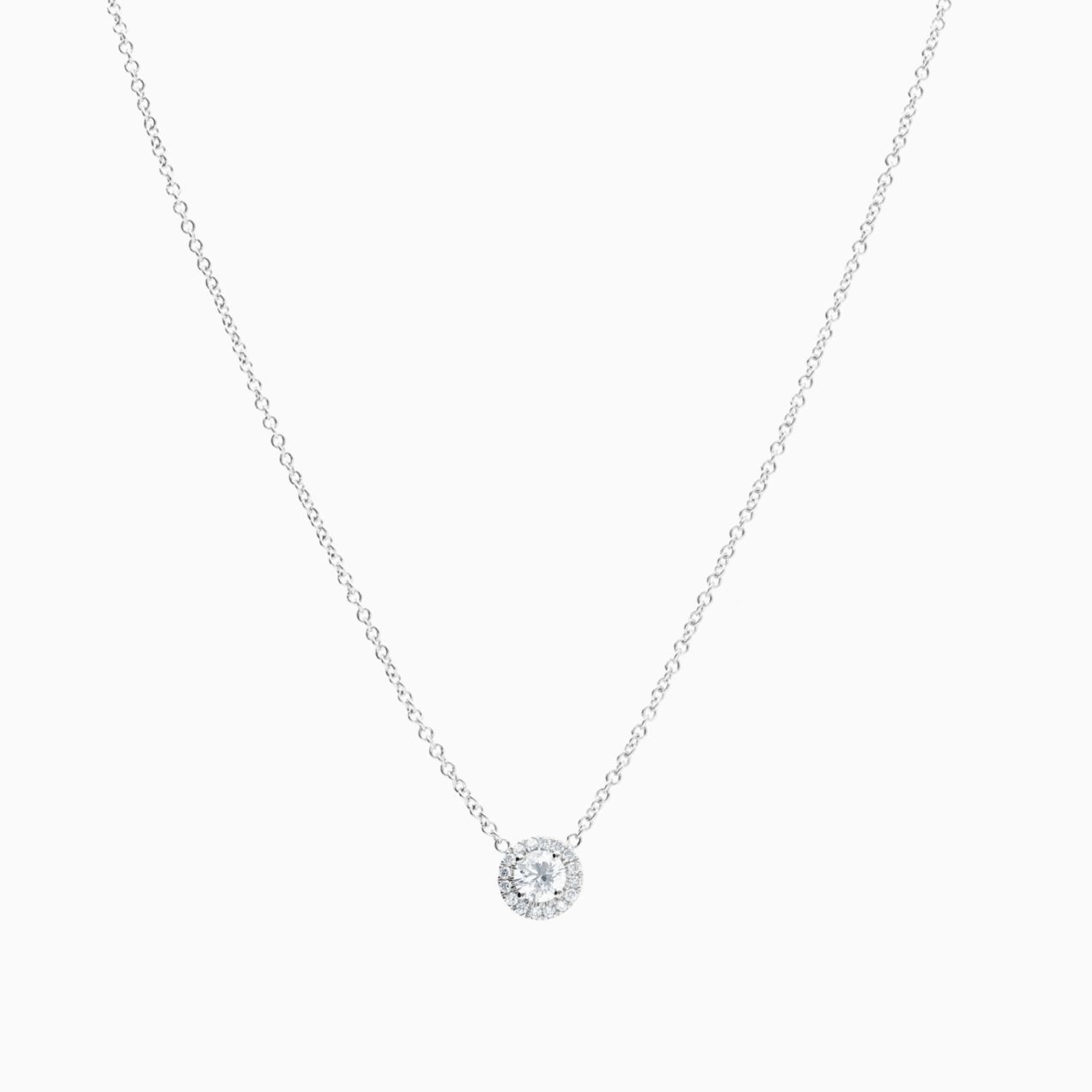 White gold solitaire pendant with central diamond and diamond halo