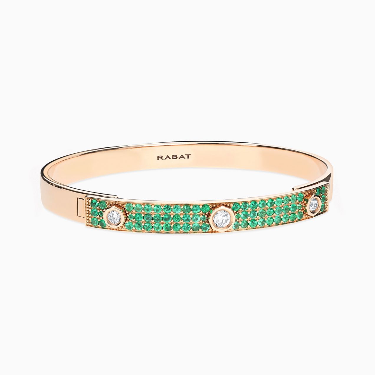 Pulsera rígida de oro rosa con tres diamantes centrales y pavé de esmeraldas verdes