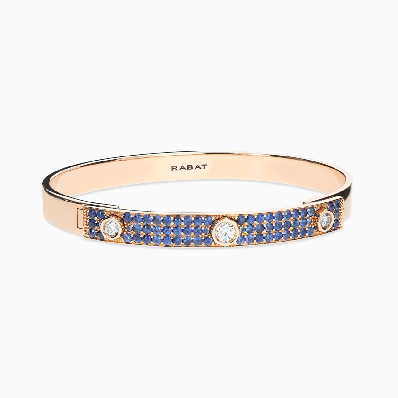 Pulsera rígida de oro rosa con tres diamantes centrales y pavé de zafiros azules