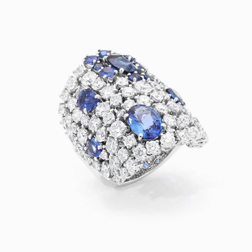 Anillo ancho de oro blanco con diamantes y zafiros azules